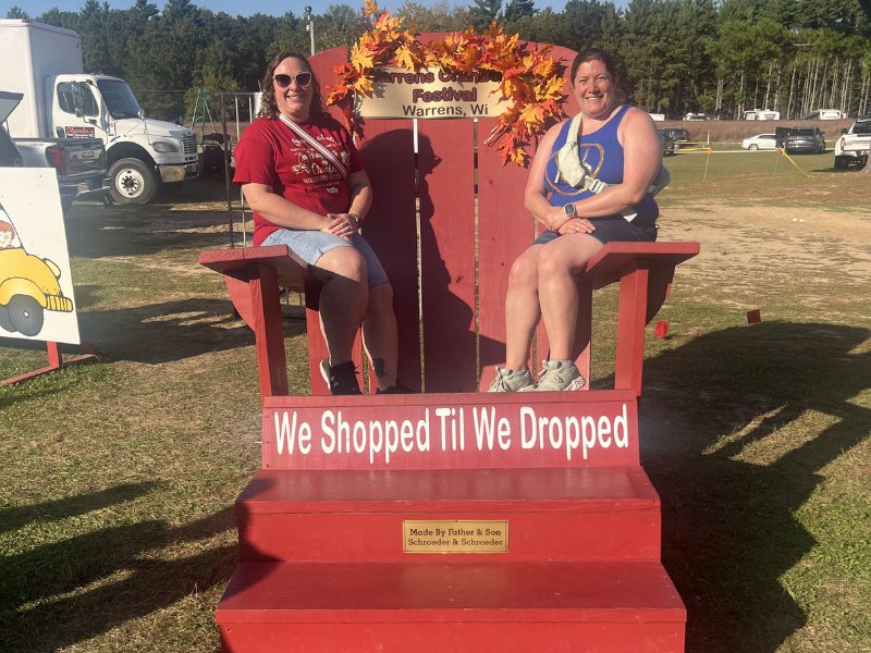 picture of two women sitting on giant red park bench